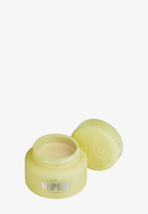 Gelbes Glas des Nabla Viper Lippenmaskenbehälters mit offenem Deckel, das die glatte Creme im Inneren und das Schlangendesign auf dem Deckel zeigt.