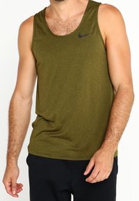 Débardeur Nike vert olive avec un logo noir sur le côté supérieur gauche, fabriqué en tissu doux et léger. Design classique sans manches avec une coupe décontractée.