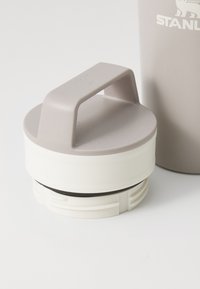 Gray plastic lid with a handle and white base, featuring a rubber seal around the edge, designed for a drink container.