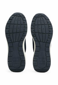 Semelles de baskets navy avec un motif en caoutchouc texturé, comportant une semelle intermédiaire blanche et des détails de marque. Rainurées pour traction et stabilité.