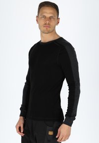 Black long-sleeve shirt with dark gray accents on shoulders. Soft fabric, crew neckline, fitted design, and streamlined look.
