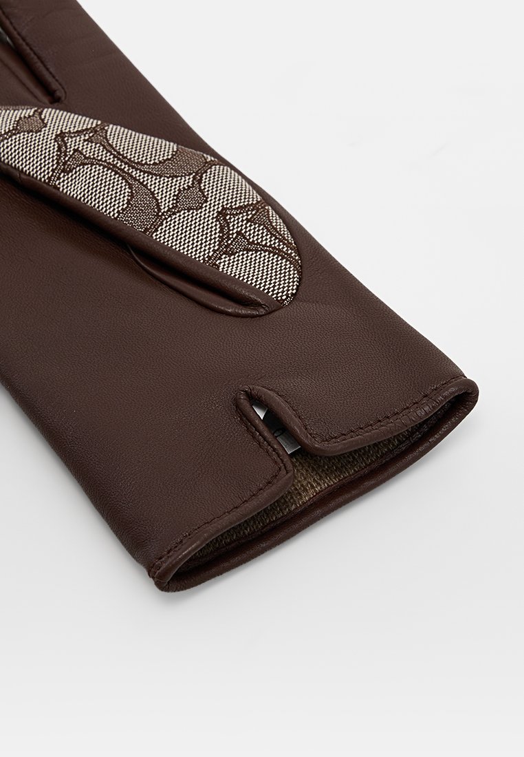 Brązowa skórzana rękawica z akcentem z wzorzystej tkaniny, z wyciętym wzorem na nadgarstku i teksturowanym wnętrzem.