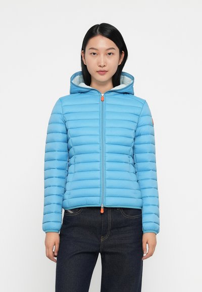 Veste en duvet bleu clair avec un design matelassé horizontal et une capuche. Présente une fermeture éclair orange et des détails de poignets côtelés.