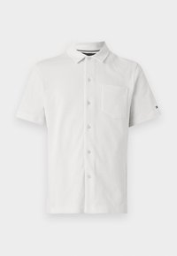 Chemise blanche à manches courtes avec boutons, col et poche poitrine, affichée à plat sur un fond clair uni.