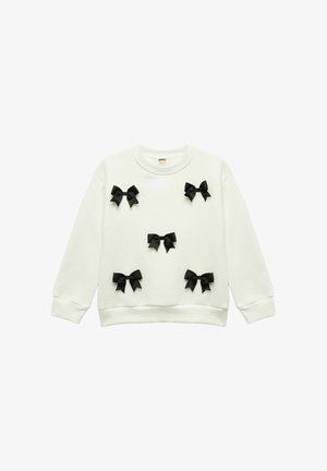 White sweatshirt made of soft fabric, featuring multiple black ribbon bows stitched across the front, round neck, and ribbed cuffs.
