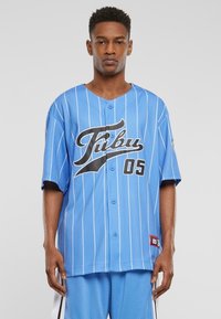 Jerseu de baseball bleu deschis cu dungi verticale albe, cu litere negre "Fubu" și numărul "05" pe față, mâneci scurte, cu închidere cu butoane.