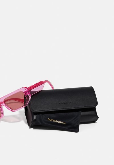 Rózsaszín átlátszó napszemüveg, gradiensek lencsékkel, a szárán egy hangsúlyos "Dolce&Gabbana" log�óval, fekete tárolótokkal kísérve.