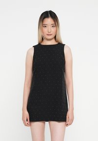 Rochie neagră fără mâneci, cu decolteu rotund, având un model cu puncte de accente argintii mici. Material neted cu o formă ajustată.