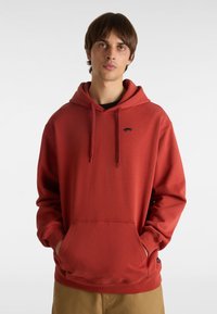 Rote Baumwollkapuzenjacke mit Kängurutasche, Zugbandkapuze und einem kleinen schwarzen Logo auf der Brust; mit gerippten Bündchen und Saum.