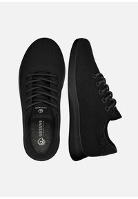 Czarne dzianinowe tenisówki z zaokrąglonym noskiem, gładkimi czarnymi sznurówkami i wyściełanymi wkładkami. Podeszwa jest teksturowana dla lepszej przyczepności i trwałości.
