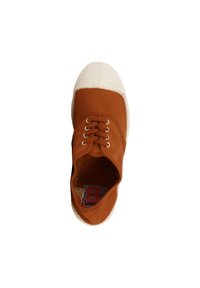 Zapatilla de lona marrón con puntera de goma blanca, seis ojales para los cordones y una suela texturizada. El interior cuenta con una etiqueta impresa.