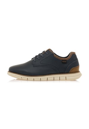 Zapatos de hombre en cuero azul oscuro con acentos marrones. Cuentan con una punta redondeada, diseño con cordones y una suela flexible de color crema.