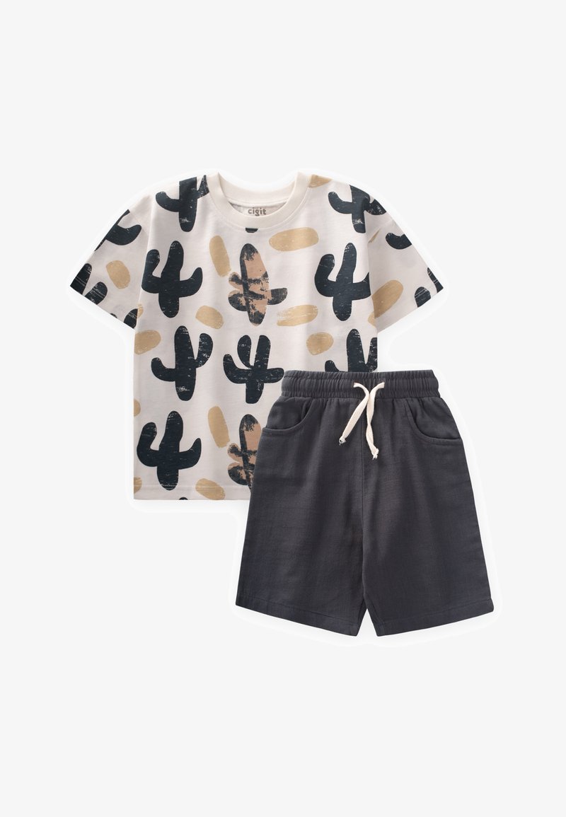 Conjunto de algodón de dos piezas que incluye una camisa blanca de manga corta con patrones de cactus en negro y beige, combinada con pantalones cortos gris oscuro y una cintura elástica.