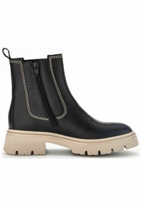 Las botas de cuero negro hasta el tobillo cuentan con un zipper lateral, costuras beige contrastantes, una suela beige gruesa y un lazo para facilitar el calzado.