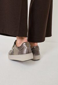 Szare i metaliczne sneakersy z mieszanych materiałów, charakteryzujące się gładką powierzchnią, subtelnym przeszyciem oraz grubą kremową podeszwą.