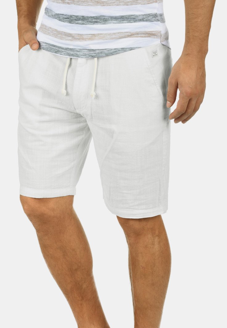Shorts en lin blanc avec un taille élastique, des poches latérales et une coupe décontractée ; le tissu texturé apporte une sensation de légèreté.