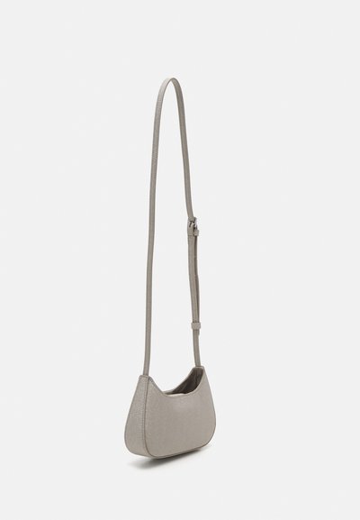 Šedá kovová taška přes rameno s křivkovým tvarem, doplněná dlouhým nastavitelným popruhem a hladkým povrchem. Minimalistický design bez viditelného kování.