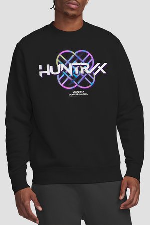 Man wearing black sweatshirt with colorful geometric design and text "HUNTR/X" and "KPOP DEMON HUNTERS" on the front.