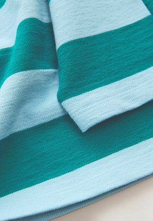 Pruhovaný textil s alternativními tmavě modrými a světlými modrými pruhy, vykazující měkkou, texturovanou tkaninu s hladkým povrchem.