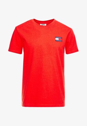 T-shirt rouge à manches courtes et col rond avec un petit logo rectangulaire Tommy Jeans sur la poitrine gauche.
