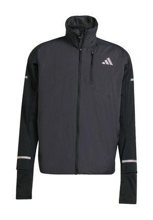 Schwarze Sportjacke mit langen Ärmeln, Frontreißverschluss, hohem Kragen, zip pocket auf der Brust und reflektierendem Adidas-Logo auf der oberen linken Seite.