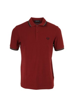 Polo en marron en coton, avec une patte de boutonnage à trois boutons et des manches courtes. Des rayures vertes et bleues soulignent le col et les poignets.