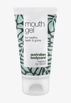 Tube de gel buccal Australian Bodycare pour dents et gencives saines avec un motif de feuilles vertes et noires sur fond blanc.
