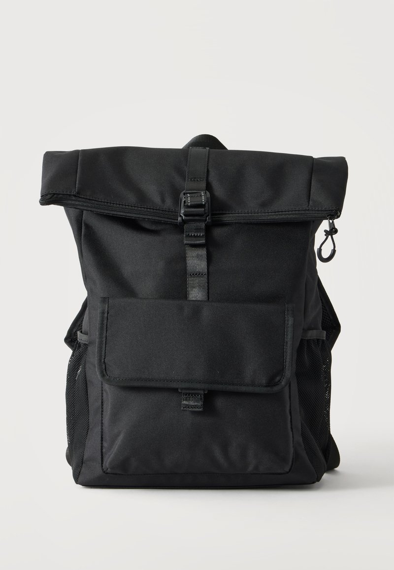 Sac à dos noir à ouverture enroulable avec poche avant, poches latérales en mesh, fermeture éclair et sangle réglable avec boucle sur fond uni.