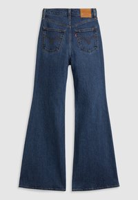Dark blue denim flared jeans with a high waist, two rear pockets featuring arcuate stitching, and a distinctive leather brand patch on the back.