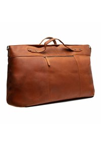 Bolso de viaje de cuero marrón con un bolsillo con cremallera, dos asas y sin acentos de hardware visibles; textura suave y forma rectangular.