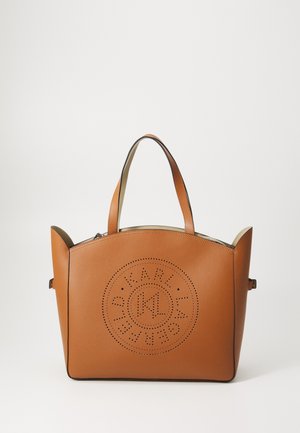 Braune Ledertasche mit abgerundeten Griffen und einem perforierten kreisförmigen Logodesign auf der Vorderseite, vor einem schlichten weißen Hintergrund.