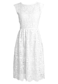 Robe en dentelle blanche avec un motif floral ajouré, des manches courtes et une jupe évasée. Des détails complexes à l'ourlet ajoutent de la texture.