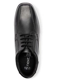 Chaussure habillée en cuir noir avec une texture lisse, à lacets, à bout arrondi et détails de couture. Taille 12 F marquée à l'intérieur.