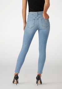 Világoskék farmer skinny farmernadrág, öt zsebes dizájnnal, magas derekú fazonnal és egy kis logó címkével a hátsó zseben.