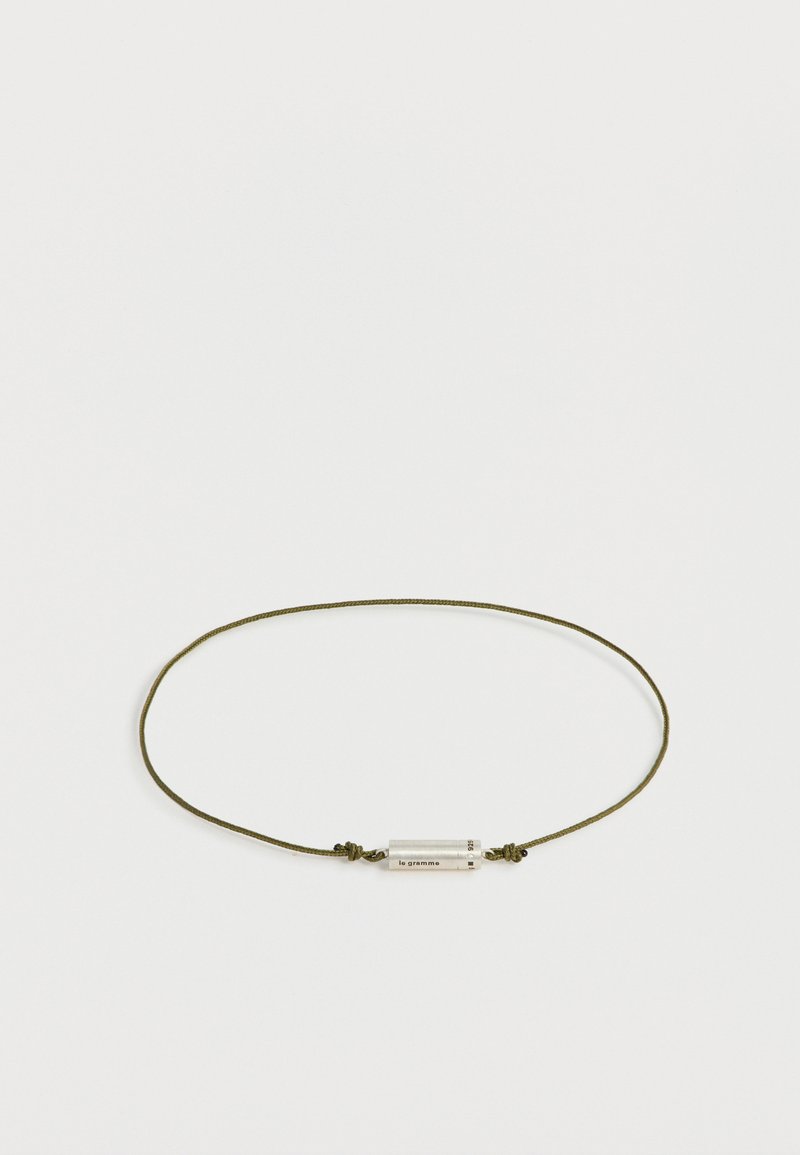 Collier fin en cordon vert olive avec un petit pendentif cylindrique en argent gravé de "le gramme" et "925".