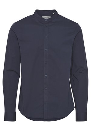 Camisa de botón marina con cuello alzado, mangas largas y una textura suave. Presenta una tapeta frontal con botones a juego y un dobladillo recto.