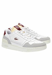 Sneaker bianche Lacoste con accenti in suede grigio, puntale perforato e branding bordeaux sulla linguetta; suola in gomma, design con lacci.