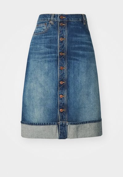 Denimkjol i medelblått med rak passform, knappstängning fram och rullad fåll. Har synliga sömmar och bronsknappar.