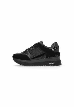 Sneaker nera con una combinazione di materiali lisci e texturizzati, chiusura con lacci, suola spessa e dettaglio del logo sul lato.
