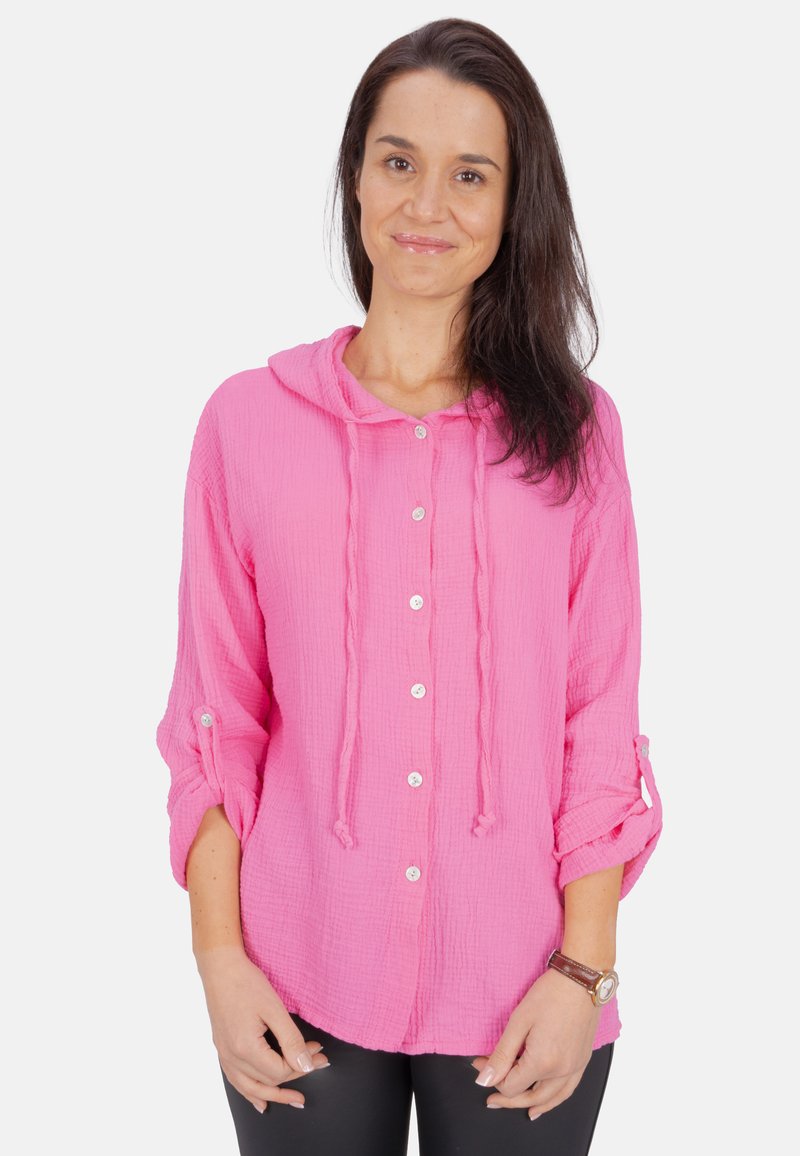 Helles rosa Hemd mit Knopfleiste und Kapuze, aus strukturiertem Stoff gefertigt. Mit hochgerollten Ärmeln und lockerer Passform.