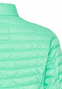Letvægts, mintgrøn pufferjakke med quiltet design, der har en stående krave og en glat, shiny overflade.