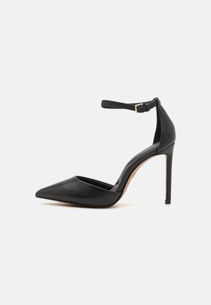 Czarne skórzane szpilki z ostrym noskiem i zapięciem w kostce. Posiadają szpilkowy obcas oraz gładką fakturę. Prosty design z złotymi elementami.