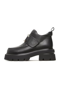 Botte noire en cuir à la cheville avec une large sangle et une boucle en argent. Semelle en caoutchouc épaisse avec des motifs de traction prononcés.