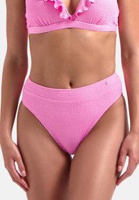 Růžový bikiny top s odstávajícími okraji a žebrovaným vzorem, spárovaný s vysokými žebrovanými kalhotkami. Materiál vypadá texturovaně s měkkým povrchem.