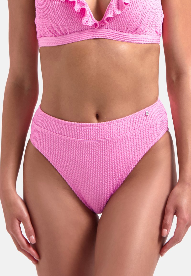 Růžový bikiny top s odstávajícími okraji a žebrovaným vzorem, spárovaný s vysokými žebrovanými kalhotkami. Materiál vypadá texturovaně s měkkým povrchem.