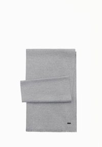 Grau-angefertigter Wollschal mit glatter Textur, mit fransigem Rand und einem kleinen schwarzen Logo-Akzent. Ordentlich auf einem weißen Hintergrund gefaltet.