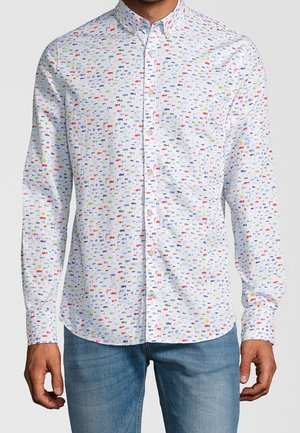 Biała koszula na guziki z długim rękawem, ozdobiona nadrukiem małych, wielokolorowych rybek, noszona z niebieskimi dżinsami, widok z przodu od ramion do bioder.