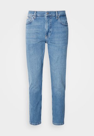 Svetlomodré džínsy s rovný strih, dizajn s piatimi vreckami a jemným vyblednutím. Obsahujú zapínanie na gombík a pútka na opasok.