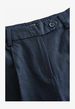 Pantaloni blu navy con una texture liscia, dotati di chiusura a bottone e fronte plissettato. Include tasche laterali e dettagli cuciti.