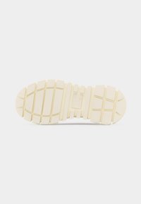 Σόλα ενός ανοιχτό μπεζ παπουτσιού με χοντρό ανάγλυφο μοτίβο που περιλαμβάνει βαθιές αυλακώσεις και ορθογώνια τμήματα για καλύτερη πρόσφυση.